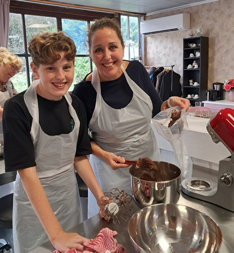 Ouder en kind maken samen een taart tijdens de ouder-kind workshop van Taart Beleving.
