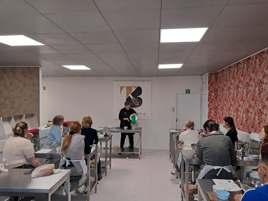 Uitleg aan een groep in de bakstudio van Taart Beleving